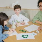 Estudantes aprendem sobre reciclagem com uma professora durante atividade em sala de aula.