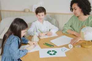 Estudantes aprendem sobre reciclagem com uma professora durante atividade em sala de aula.