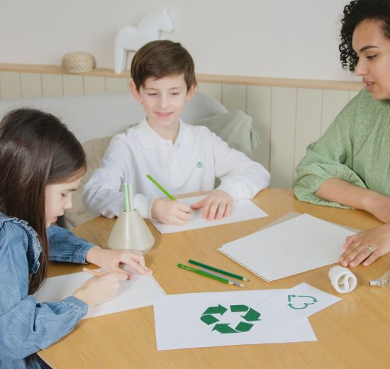 Estudantes aprendem sobre reciclagem com uma professora durante atividade em sala de aula.