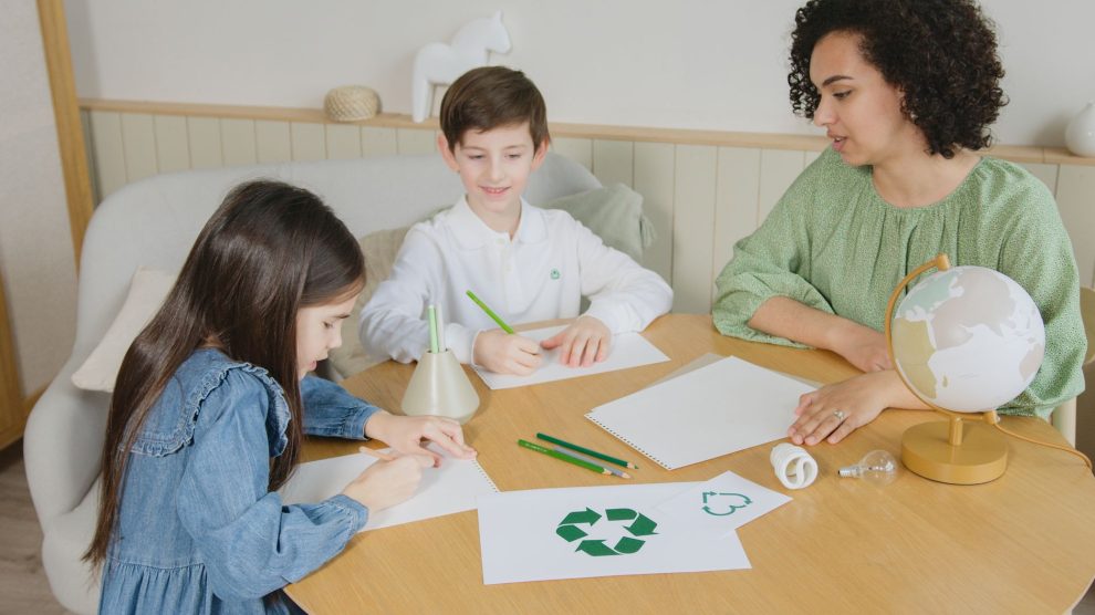 Estudantes aprendem sobre reciclagem com uma professora durante atividade em sala de aula.