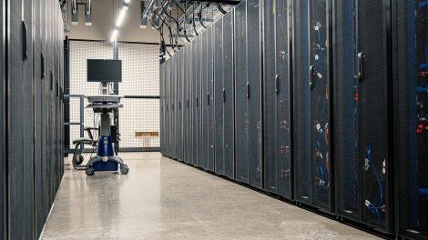 Racks metálicos com servidores, equipamentos de rede e cabos em um datacenter moderno.