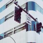 Semáforos instalados em uma via urbana, diante de edifícios