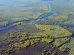 Paisagem de rio e áreas alagadas do Pantanal, com vegetação verde às margens e céu aberto
